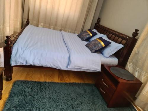 1 dormitorio con cama con almohadas y alfombra en Unia fancy flats - studio apartment two en Kampala