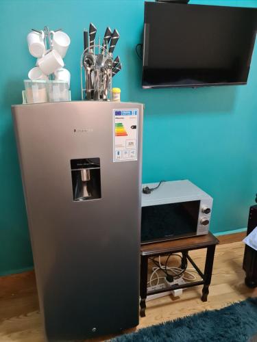 a refrigerator next to a table with a tv at Unia fancy flats - studio apartment two in Kampala