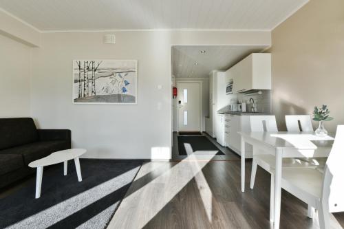 a living room and kitchen with a white table and chairs at Punkaharju Resort in Punkaharju