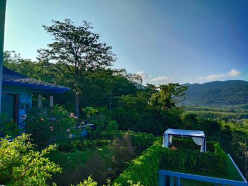 a garden with a blue bench in the grass at Khaolak Blue Sky Villa in Khao Lak