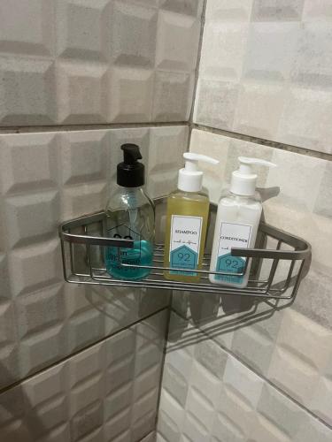 a shelf with three bottles ofodorizers on a wall at Heath Villa - private room in Port Elizabeth