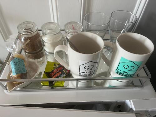 two mugs and glasses on a shelf in a refrigerator at Heath Villa - private room in Port Elizabeth