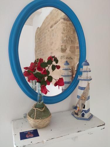 a mirror on a shelf with a vase with a flower at Acasadelpescatore in San Benedetto del Tronto