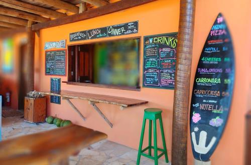 a restaurant with a surfboard on the wall and a bar at Pousada Kite Guajiru in Itarema