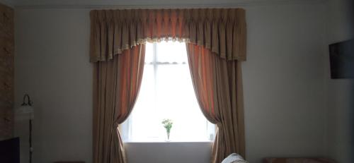 a large window with curtains in a room at Westend in Ryde