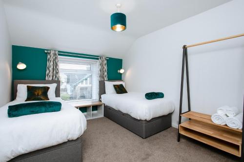 a bedroom with two beds and a window at Burnside Cottage, Wark, Hexham in Hexham