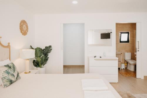 Habitación blanca con cama blanca y baño. en Quinta Monteiro de Matos - Enoturismo, en Santarém