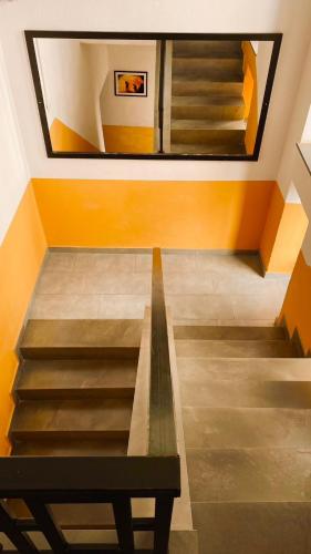 a staircase with a bench in a room with orange walls at Hotel Antigone in Tirana