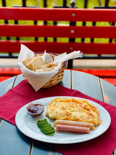 a plate of food with a hot dog and chips and a basket of chips at Hotel Antigone in Tirana