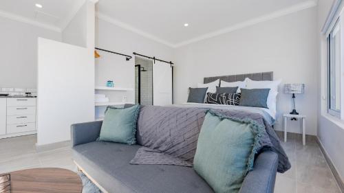 a living room with a bed and a couch at 34.4 Degrees South Studio Apartment in Agulhas