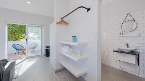 uma casa de banho branca com um lavatório e uma janela em 34.4 Degrees South Studio Apartment em Agulhas