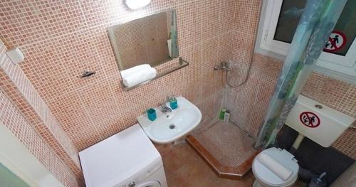uma casa de banho com um lavatório, um WC e um espelho. em Athens City Themis13 em Atenas