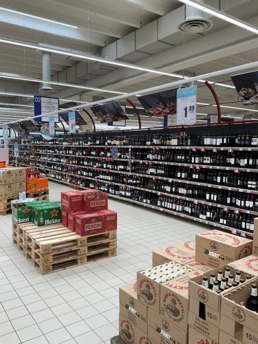 a store aisle with boxes of wine in a store at RESORT VILLAGE AQUA MARINA FAMILY - Daily Rooms Tidying - CocktailsBar- Pet Friendly - with Hypermarket - Delivery Restaurant-Pizzeria - Room Breakfast with supplement - Ultra Fast Wi-Fi - Play Area for children - Olympic Swimming Pool - Parking in Caorle