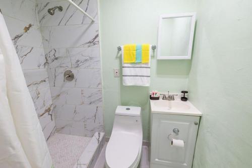 een witte badkamer met een toilet en een wastafel bij Private Suite in North Miami in North Miami Beach