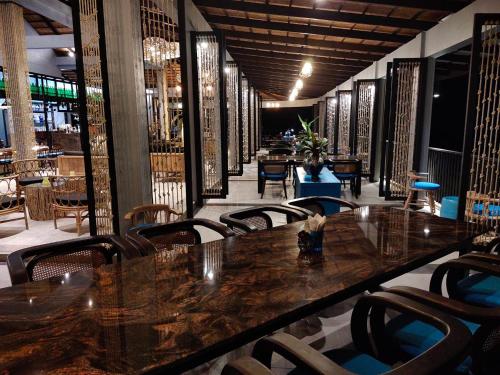 a dining room with a long table and chairs at Khaolak Blue Sky Villa in Khao Lak