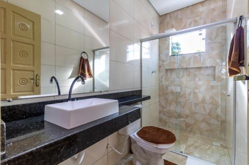 La salle de bains est pourvue d'un lavabo, de toilettes et d'une douche. dans l'établissement Villa Sunset, à Arraial d'Ajuda
