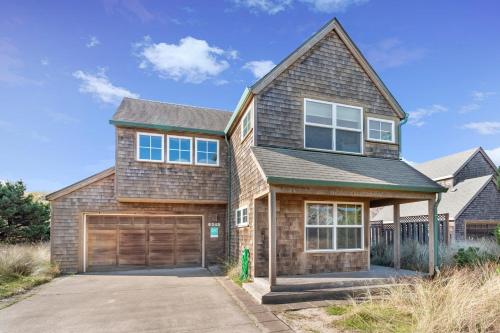 a house with a garage in front of it at The Break in Pacific City
