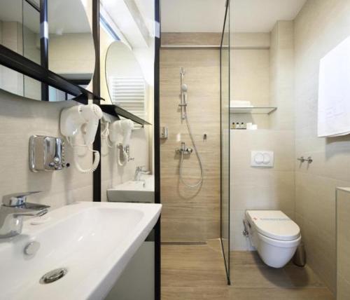 a bathroom with a shower and a sink and a toilet at Hotel Koncept Residence in Sarajevo
