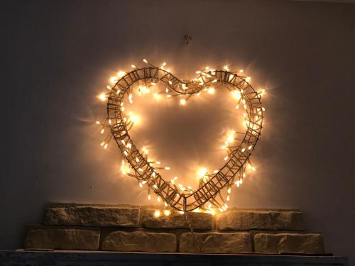 a heart shapedreath with lights on a brick wall at AUX PORTES DE LA CAMARGUE STUDIO BALNEO PISCINE in Tarascon