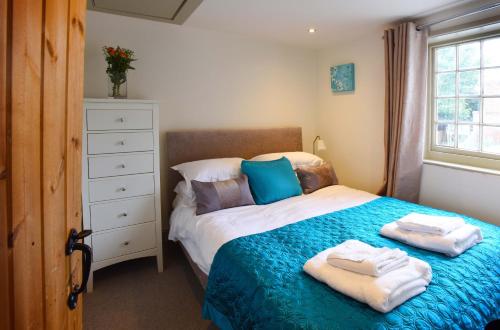 a bedroom with a bed with towels on it at Fireman's Cottage in Canterbury