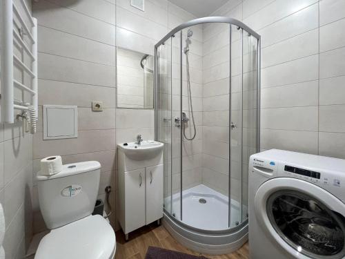a bathroom with a shower toilet and a washing machine at Апартаменти по вул Галицька in Ivano-Frankivsʼk