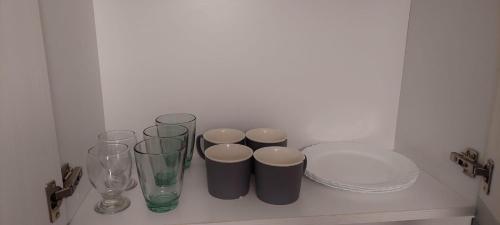 a shelf with several vases and glasses on it at Apart Plaza in San Salvador de Jujuy