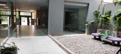 a lobby of a building with a bench and plants at Apart Plaza in San Salvador de Jujuy
