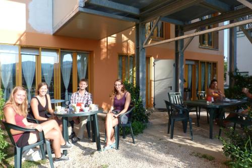 un gruppo di persone seduti ai tavoli fuori da una casa di Ostello Torino a Torino