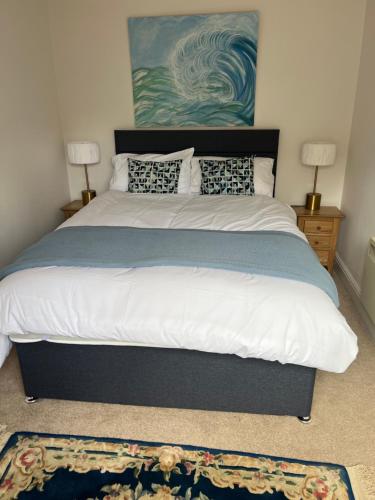 a bedroom with a large bed with two lamps and a rug at The Old Dairy Steep,Petersfield in Collyers Estate in the South Downs National park in Petersfield