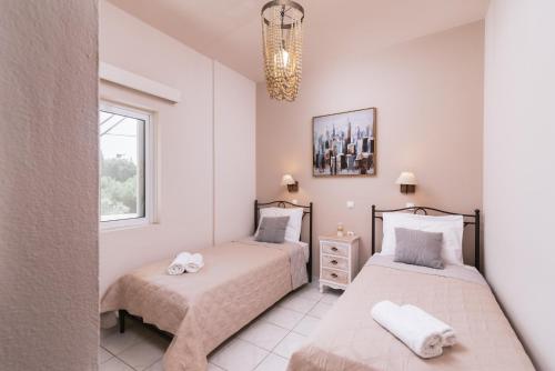a bedroom with two beds and a window at Filia Apartments in Pitsidia