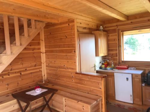 a kitchen in a log cabin with a table in it at Zlatarski raj in Muškovina