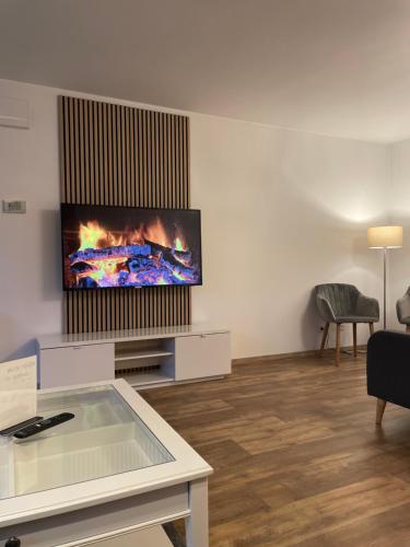 a living room with a flat screen tv on a wall at Ferienwohnung auf dem Sonnenhang in Bad Rothenfelde