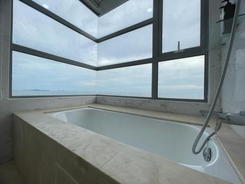 a large bath tub in a bathroom with a window at Silverscape,Res -- Seaview -- Balcony -- 7 pax in Melaka
