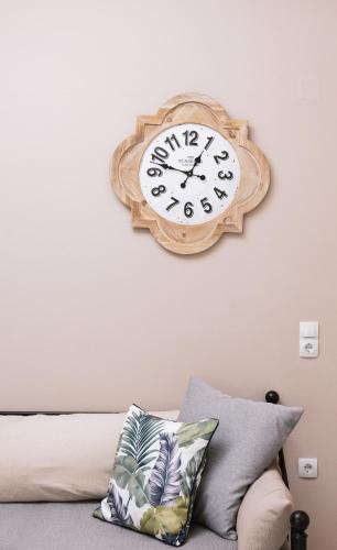 a clock hanging on a wall above a bed at Filia Apartments in Pitsidia
