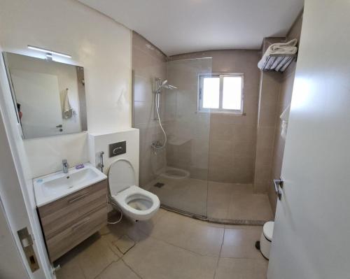 a bathroom with a toilet and a sink and a shower at Byblos Prime in Aqaba