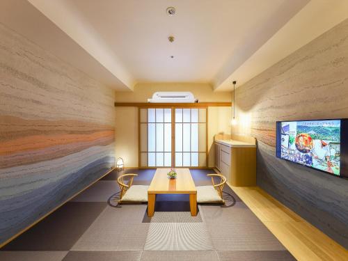 a room with a table and two chairs and a tv at Hotel New Wakasa in Nara
