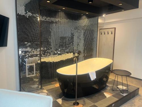 bañera en una habitación con pared de cristal en Hotel NIKS, en Sevlievo