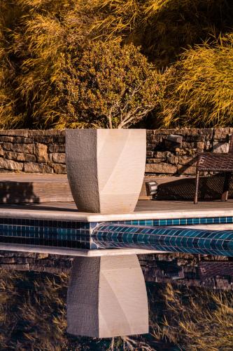 a reflection of a bench in a pool of water at Pousada Boutique Itaipava in Itaipava