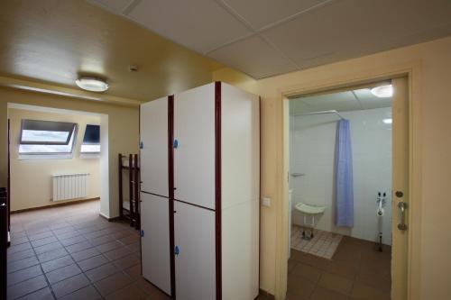 a room with a large white cabinet and a hallway at Alberg Núria Xanascat in Queralbs