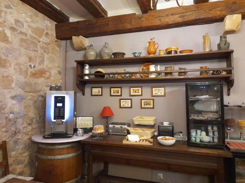 a kitchen with a counter with a coffee maker on it at Hôtel Berceau Du Vigneron in Turckheim