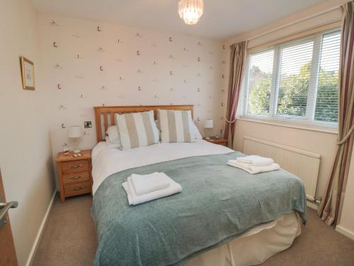 a bedroom with a bed with two towels on it at Number Six in Burniston
