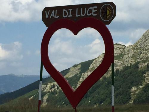 a sign in the shape of a heart with mountains in the background at Casa Dalja in Abetone