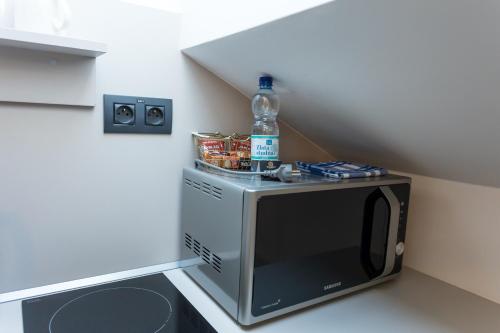 a microwave with a bottle of water on top of it at Apart Hotel GOLDEN apartments in Košice