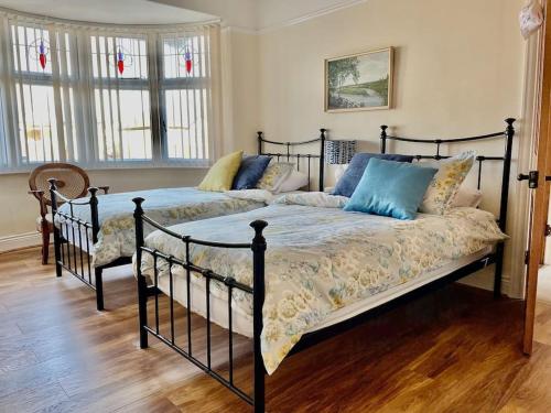 2 camas num quarto com pisos e janelas em madeira em Kelvinside, Seahouses, 2 minute walk into village em Seahouses