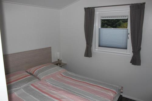 a bedroom with a bed and a window at Mein-Mosel-Chalet-Haus-Birke in Koblenz