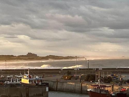 a harbor with boats on the water and a castle at Kelvinside, Seahouses, 2 minute walk into village in Seahouses