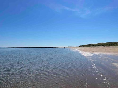 a beach with water and a blue sky at Kelvinside, Seahouses, 2 minute walk into village in Seahouses
