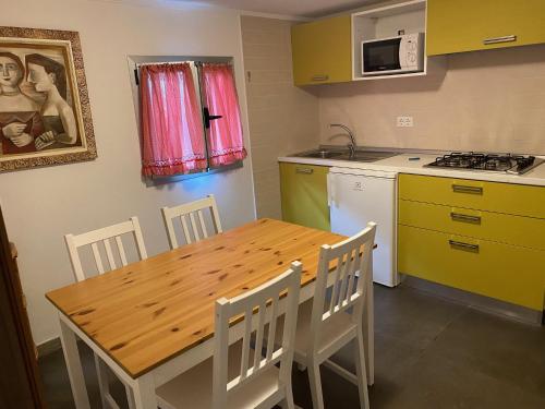 a kitchen with a wooden table and a table and chairs at Camping Roma in Ventimiglia