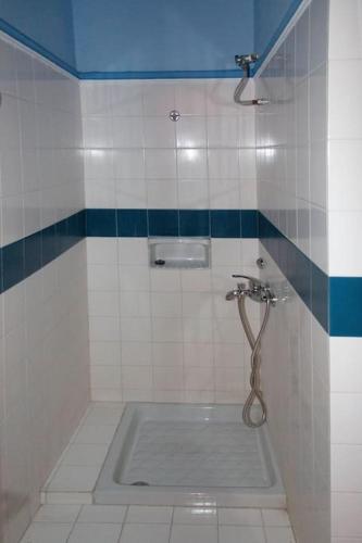 a tiled bathroom with a shower with a sink at Villa EnElladi in Neos Pirgos