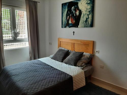 a bedroom with a bed and a picture on the wall at Apartamento Ines, Dehesa de Campoamor,900m from the sea , swimming pool & tennis court in Dehesa de Campoamor